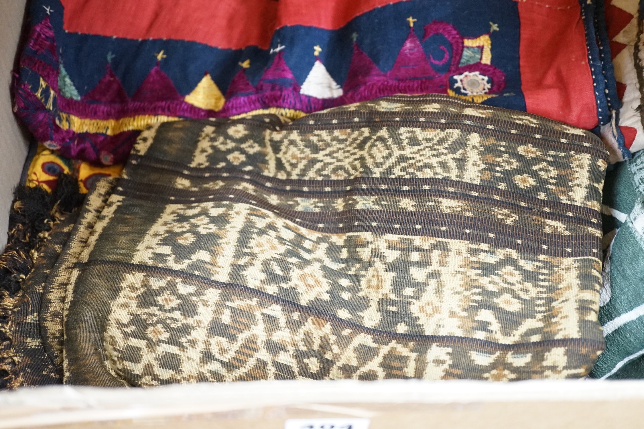 A collection of Indian mirrored worked hangings, a length of batik fabric and a woven shawl